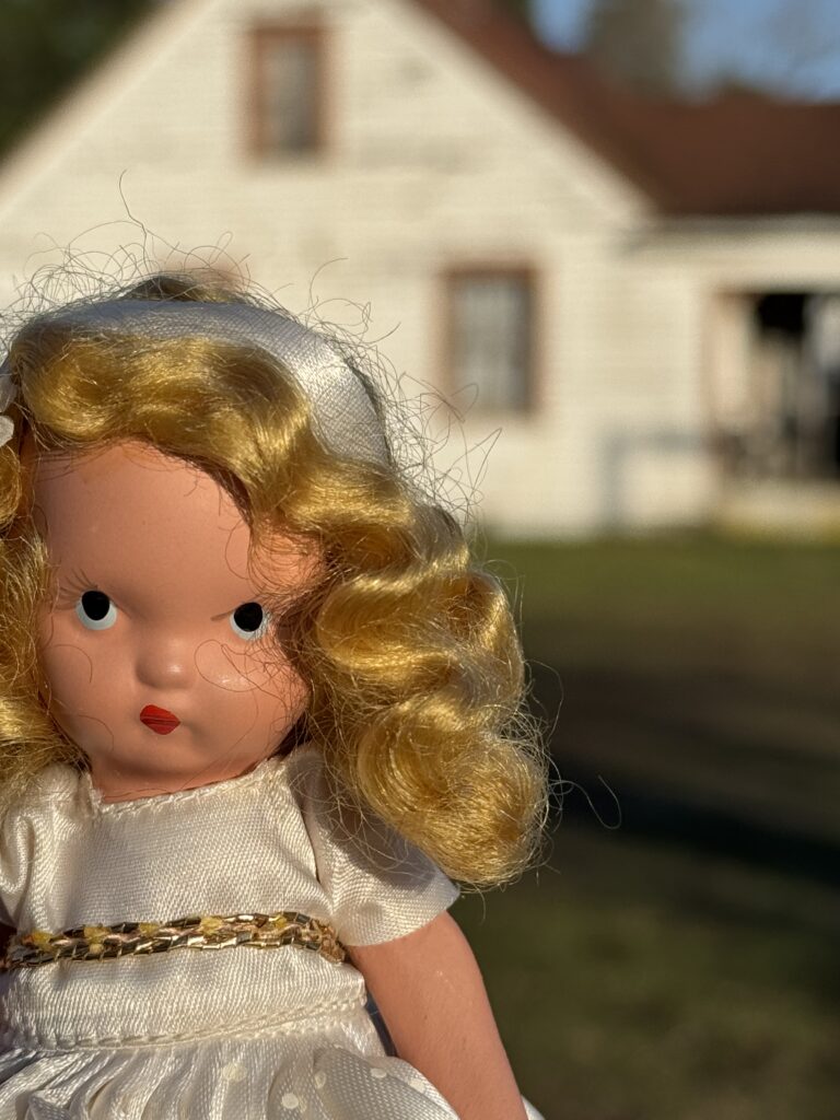 clara the haunted doll in front of an old building at fort steilacoom